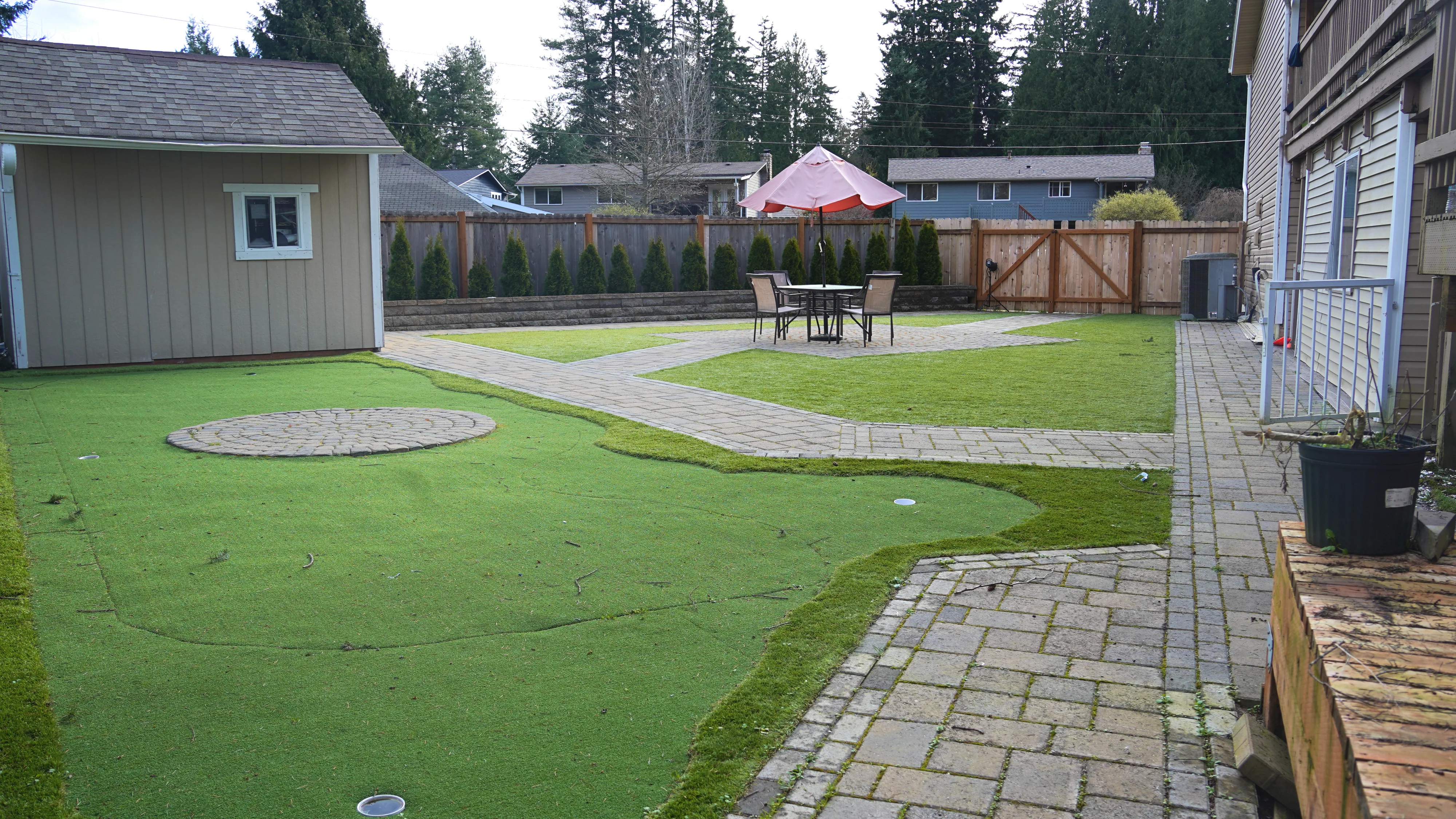 Backyard view with paver walkway, lawn, and outdoor seating area