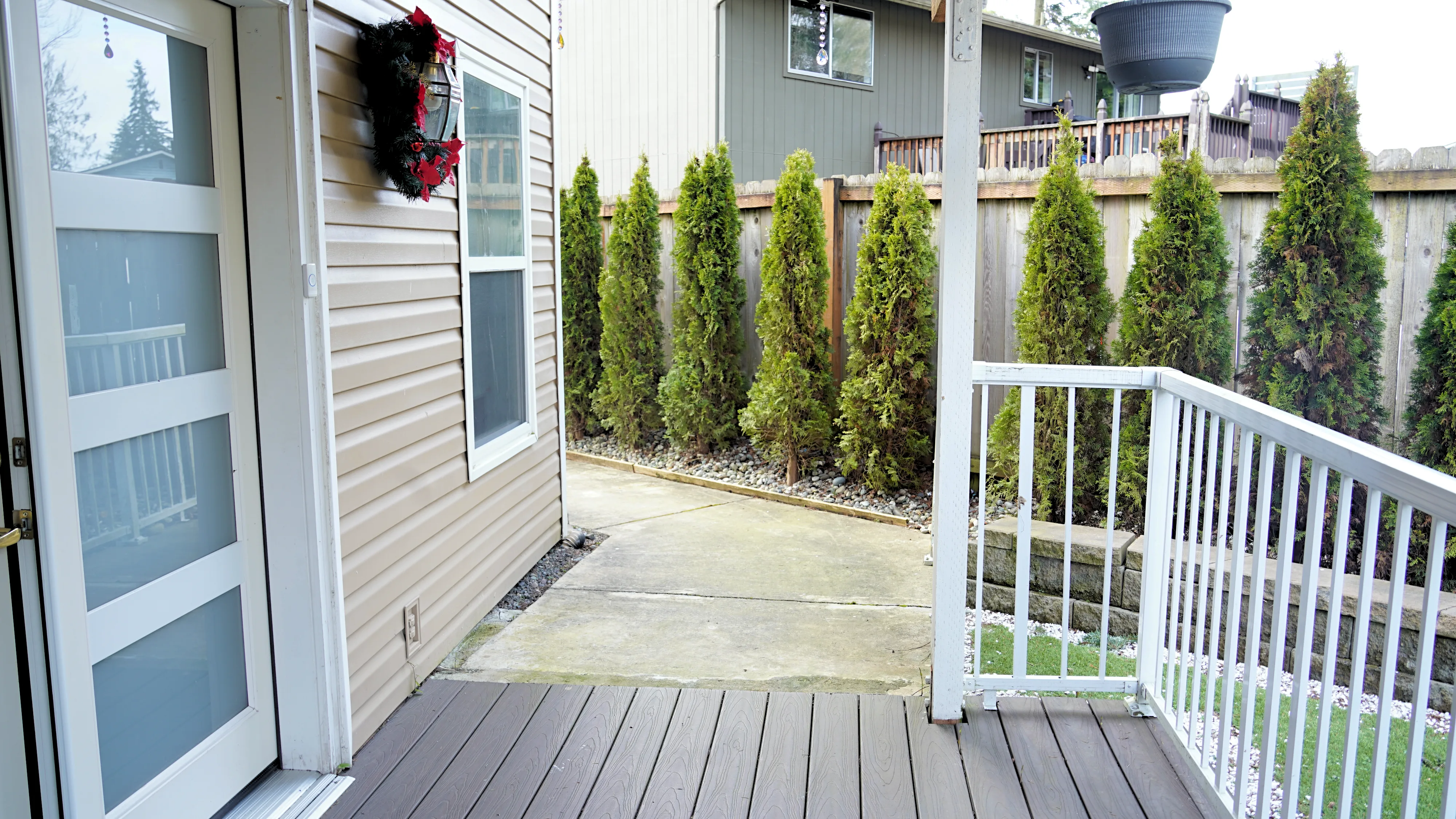 Side deck entry with railing and evergreen landscaping