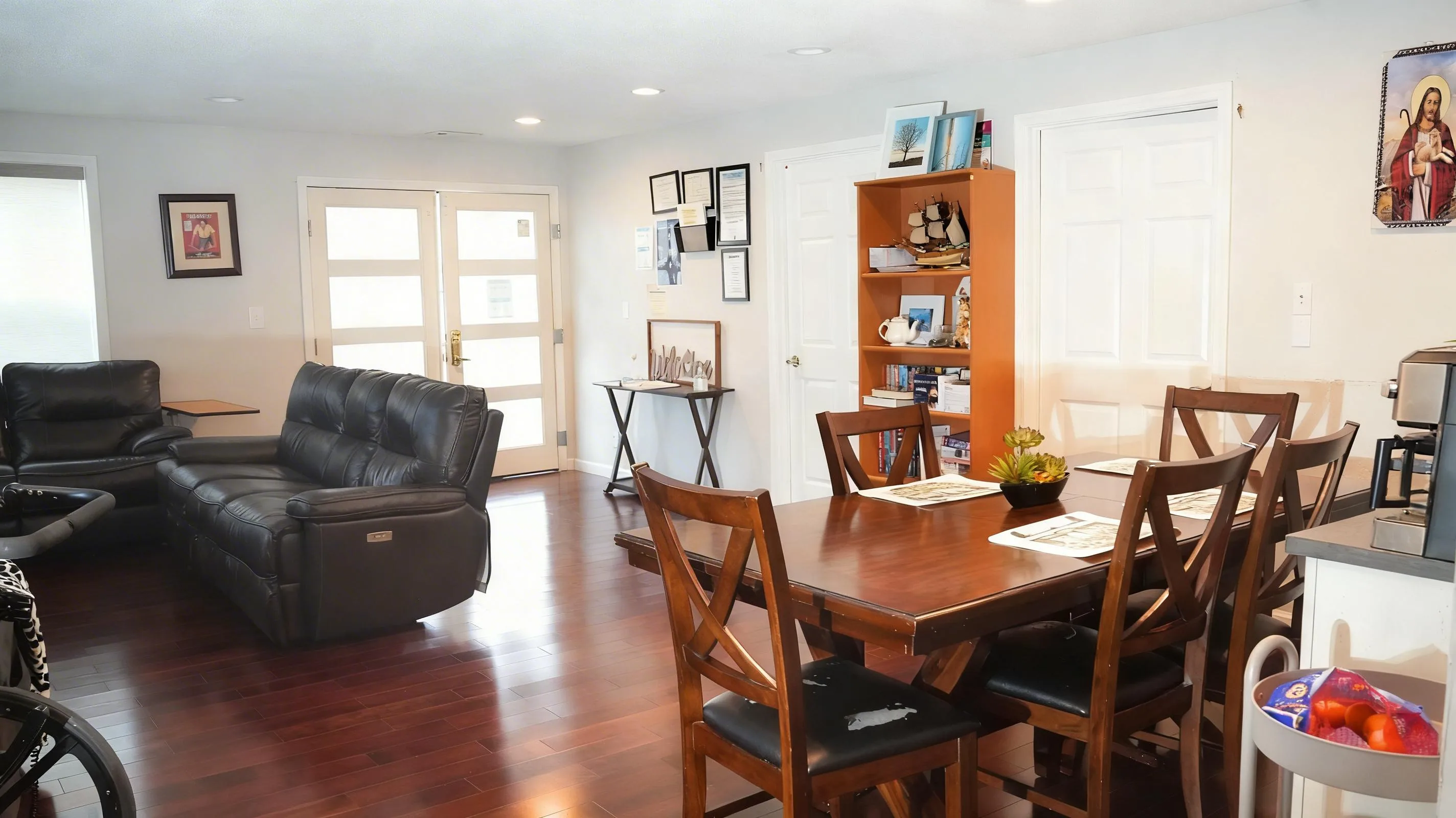 Open-plan dining and living area with bookshelf and French doors