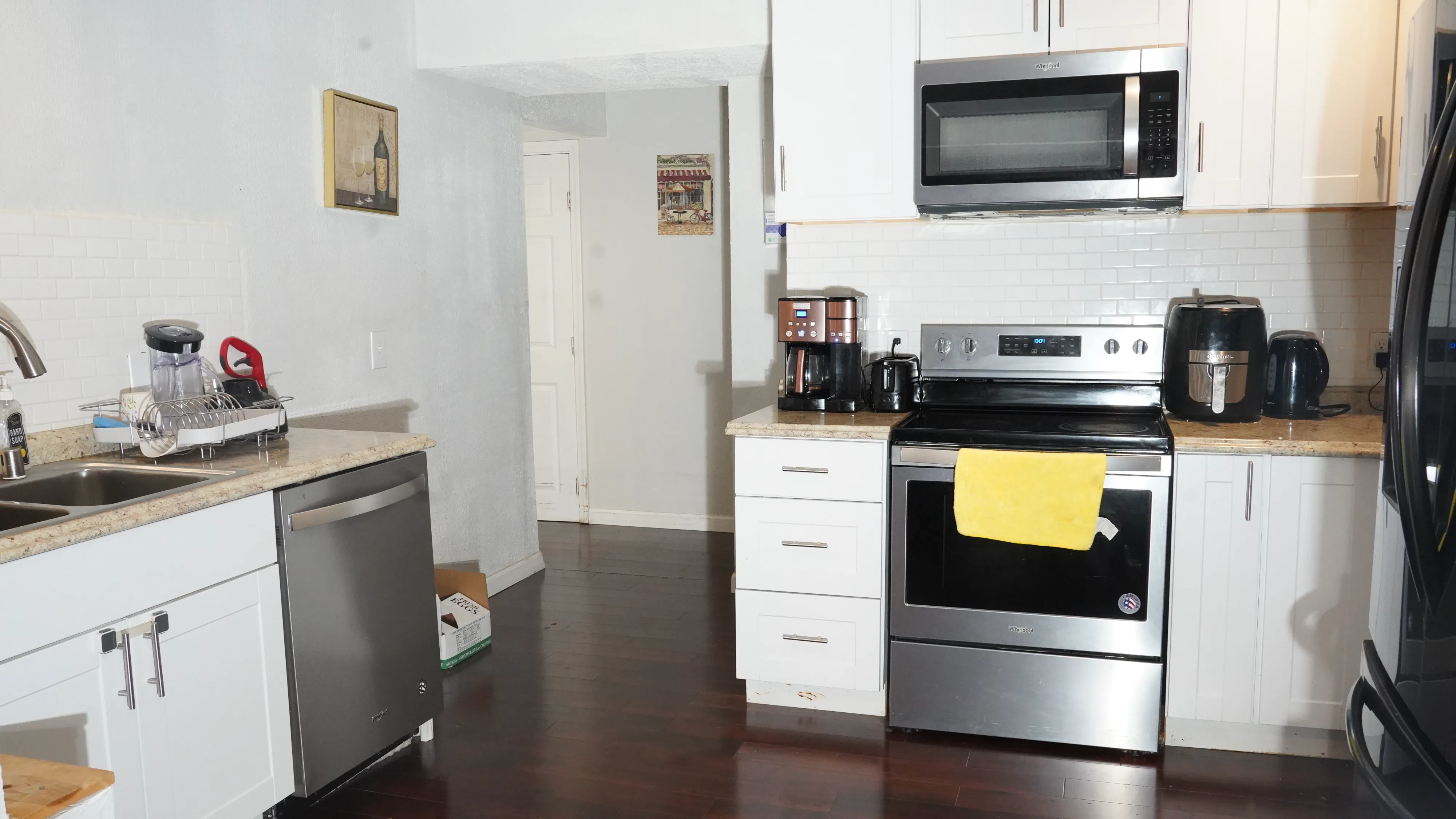 Kitchen with dishwasher, stove, subway tile backsplash, and hardwood floors