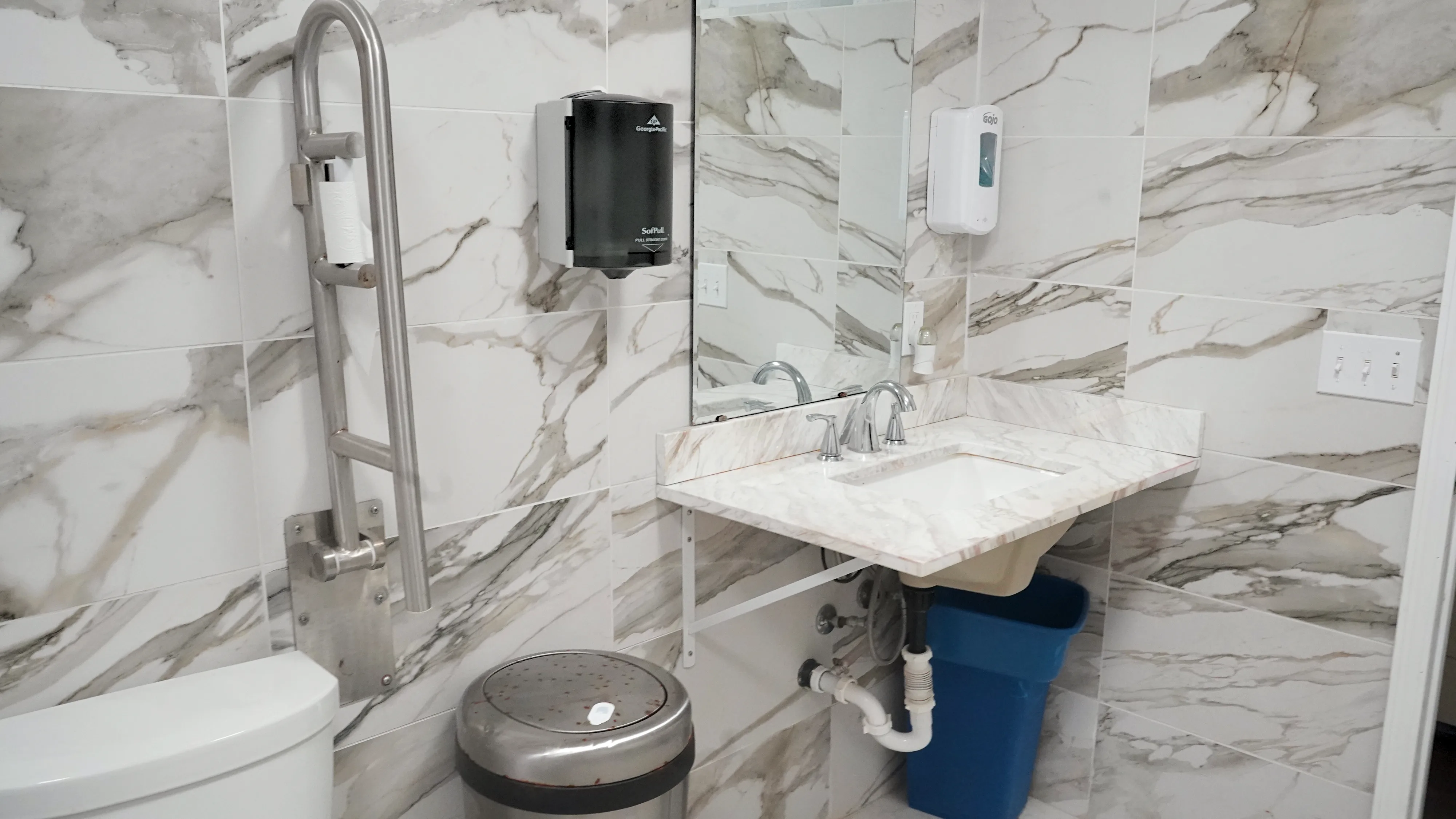 Bathroom vanity with marble countertop, grab bars, and accessible sink