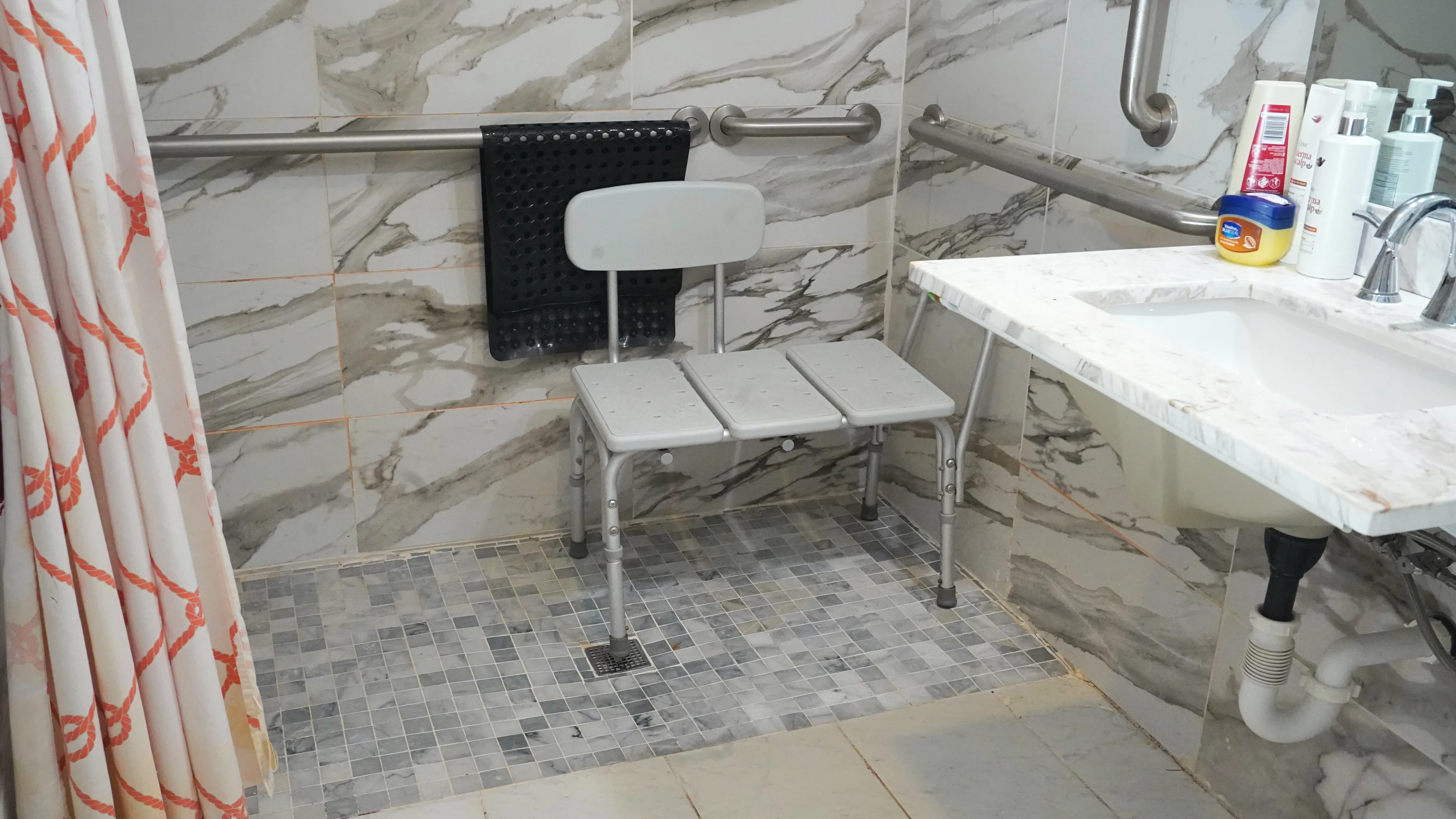 Accessible shower area with transfer bench and safety rails